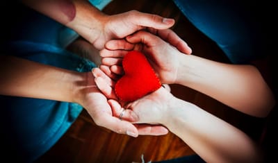 Hands holding a felt heart symbolizing care