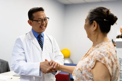 Healthcare professional greeting a resident in an office
