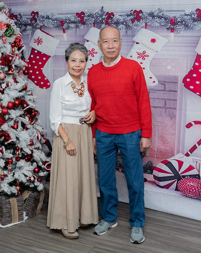 Residents posing together in front of a festive backdrop
