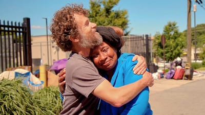 Two people embracing outdoors, showing emotion.