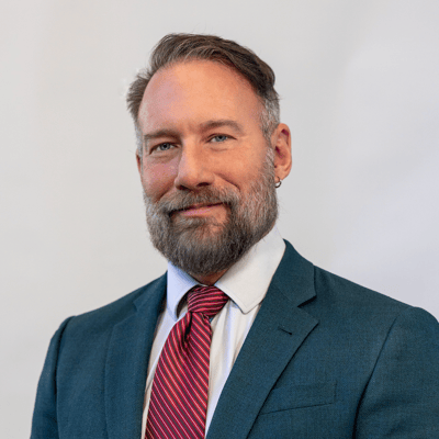 A man in a suit with a beard and tie