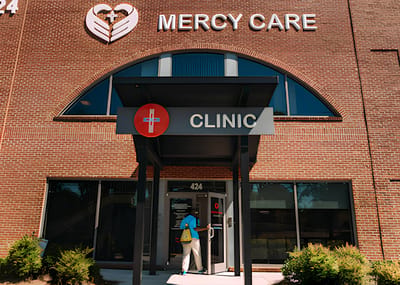 Entrance of Mercy Care clinic with a person entering