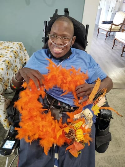 Resident joyfully creating a colorful craft project