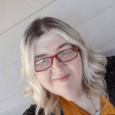 Perfect Care, nursing home in Americus, GA — Woman with blonde hair and red glasses smiling