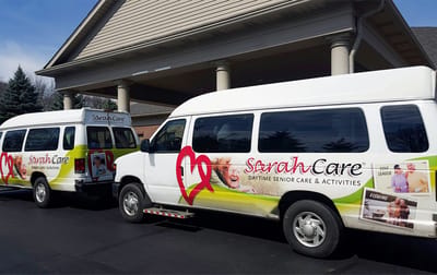 Sarah Adult Day Services, nursing home — Two branded vans parked outside a senior care facility