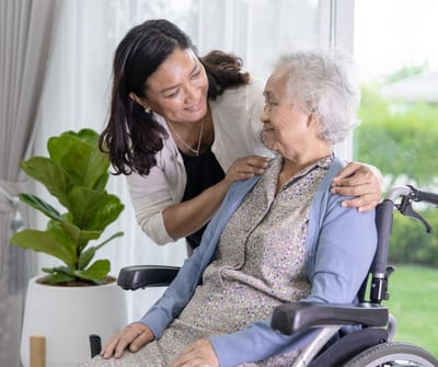 Sarah Adult Day Services, nursing home — Caregiver assisting elderly woman in a bright room