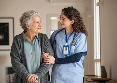 Serenity Adult Day Health II, adult day care in Warner Robins, GA — Nurse assisting an elderly woman in a care facility