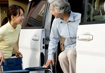 Sarah Adult Day Services, nursing home — Caregiver assisting a senior woman exiting a vehicle