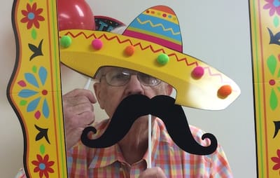 Senior man with a sombrero and mustache prop