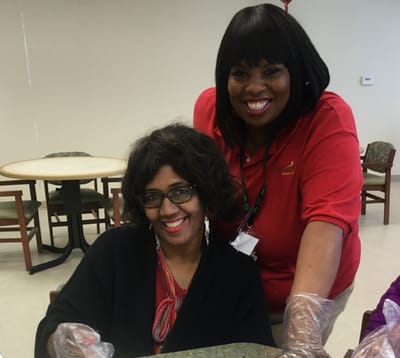 Staff member assisting a resident in an activity room