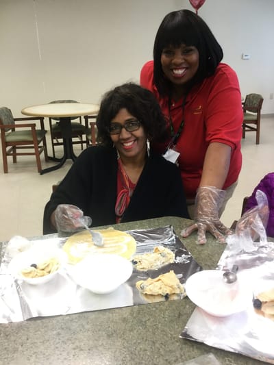 Staff and resident preparing food together
