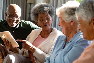 Your Parent’s Place, nursing home — Seniors engaged in a group conversation with a tablet