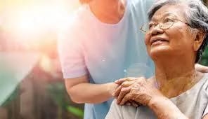 Your Parent’s Place, nursing home — Caregiver assisting a smiling elderly woman outdoors