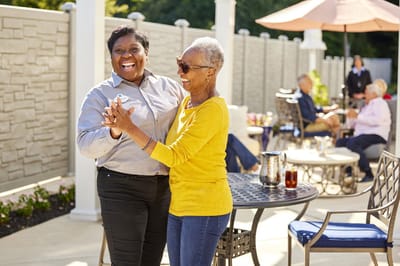 Arbor Terrace at Cascade, memory care in Atlanta, GA — Residents enjoying a cheerful dance in an outdoor setting