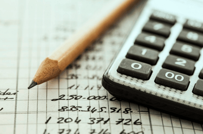 Arbor Terrace at Cascade, memory care in Atlanta, GA — Calculator and pencil on financial documents with graphs