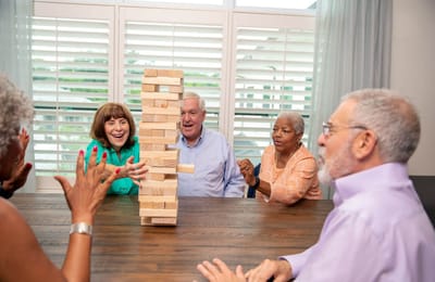Arbor Terrace at Cascade, memory care in Atlanta, GA — Participants playing Jenga in a bright activity room