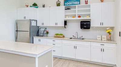 Modern kitchen area with white cabinetry and a sink