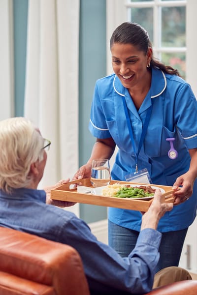 Staff member serving food to a resident