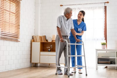 Caregiver assisting an elderly resident in a bright room