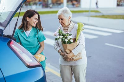 Staff assisting a resident with groceries outdoors