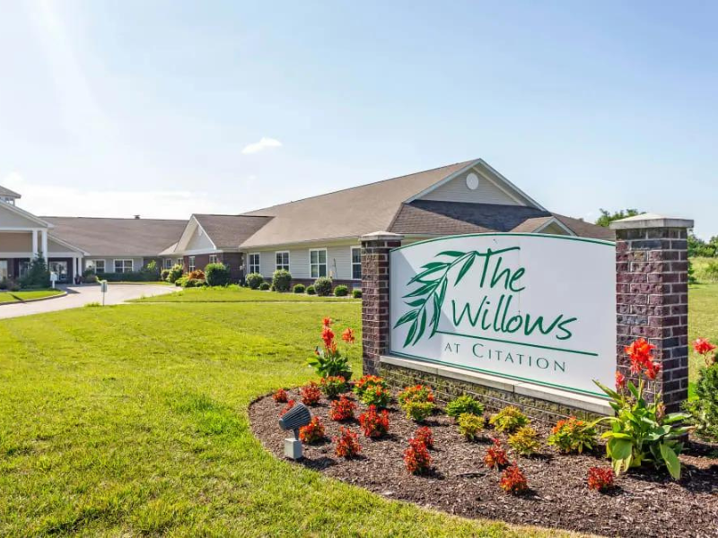 Exterior view of The Willows at Harrodsburg with flowerbed