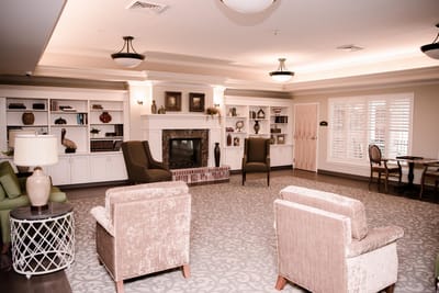 A cozy common area with comfortable seating and shelves.