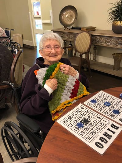 Resident enjoying bingo with a handmade pillow