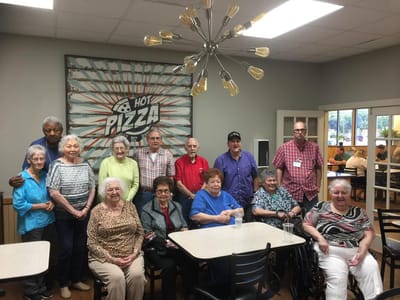 Group of residents enjoying pizza in the dining area