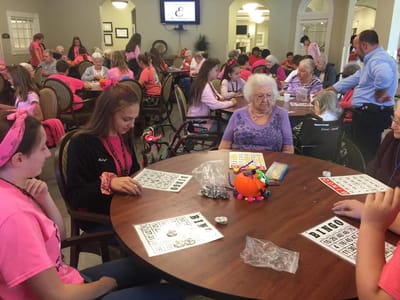 Residents and volunteers playing bingo in a common area