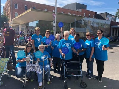 Residents and staff participating in a community event with signs