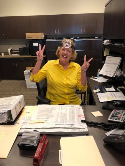 Staff member with a playful expression at her desk