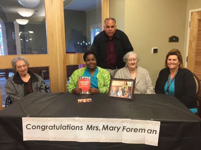 Residents and staff celebrating a milestone at a table