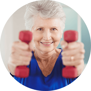 Carrollton Nursing & Rehab Ctr, Nursing Home in Carrollton, GA — Senior woman exercising with dumbbells in a lively setting