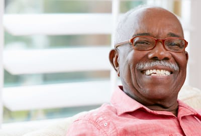 Carrollton Nursing & Rehab Ctr, Nursing Home in Carrollton, GA — Smiling senior man with glasses in a bright room