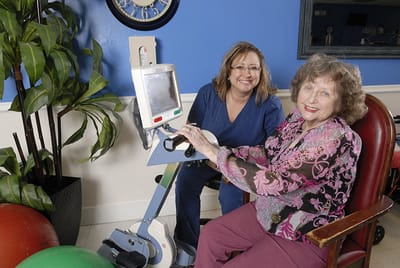Carrollton Nursing & Rehab Ctr, Nursing Home in Carrollton, GA — Therapist assisting senior resident with rehabilitation equipment