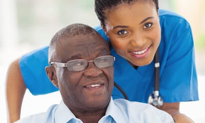 Coastal Manor, Nursing Home in Ludowici, GA — Happy resident with caregiver in a senior living facility