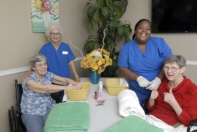 Carrollton Nursing & Rehab Ctr, Nursing Home in Carrollton, GA — Residents enjoying a manicure session with caregivers