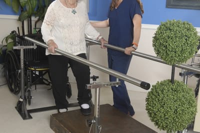 A resident receiving assistance during therapy with a staff member