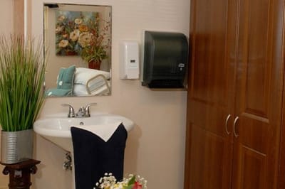 Interior view of a resident room with a sink and floral art