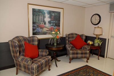 Comfortable lounge area with chairs and a floral painting