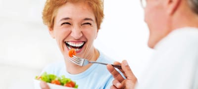 Resident enjoying a meal with a joyful expression