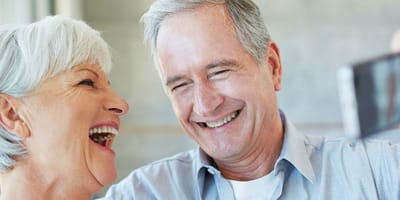 Two seniors joyfully laughing together