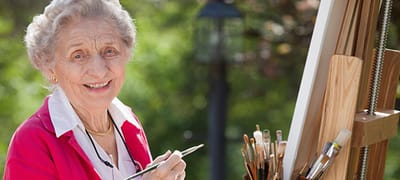 A resident painting outdoors with art supplies.