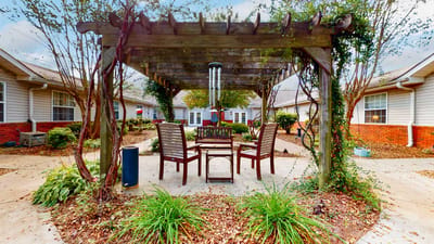 Outdoor seating area with a pergola and greenery