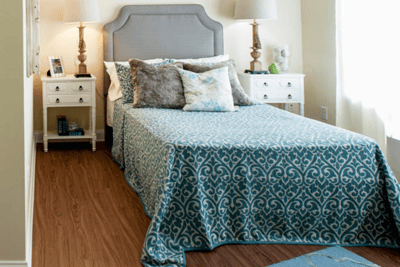 Brightly decorated single resident room with bed