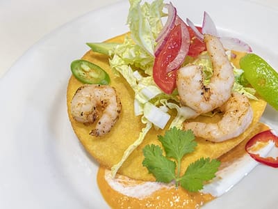 Plate of shrimp tacos with garnishes
