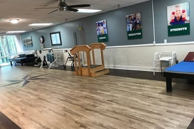 Rehabilitation exercise area with equipment and motivational posters