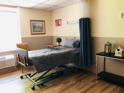 A cozy resident room with adjustable bed and decor