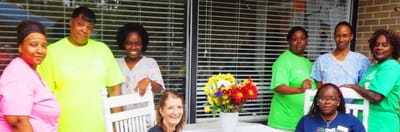 Carrollton Nursing & Rehab Ctr, Nursing Home in Carrollton, GA — Group of staff members posing with flowers on a patio