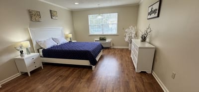 A well-furnished resident room with a bed and decor
